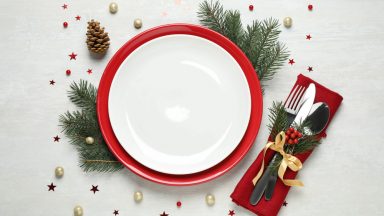 Une assiette posée sur une table de Noël avec des décorations rouges et vertes.